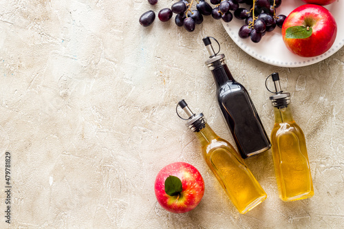 Apple and grape balsamic vinegar in glass bottles with fresh fruits