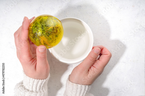 Making tea with Trendy modern tea ball bombs. Tea balls with dried tea, cups, lemon and mint, with classic white cup, top view copy space photo