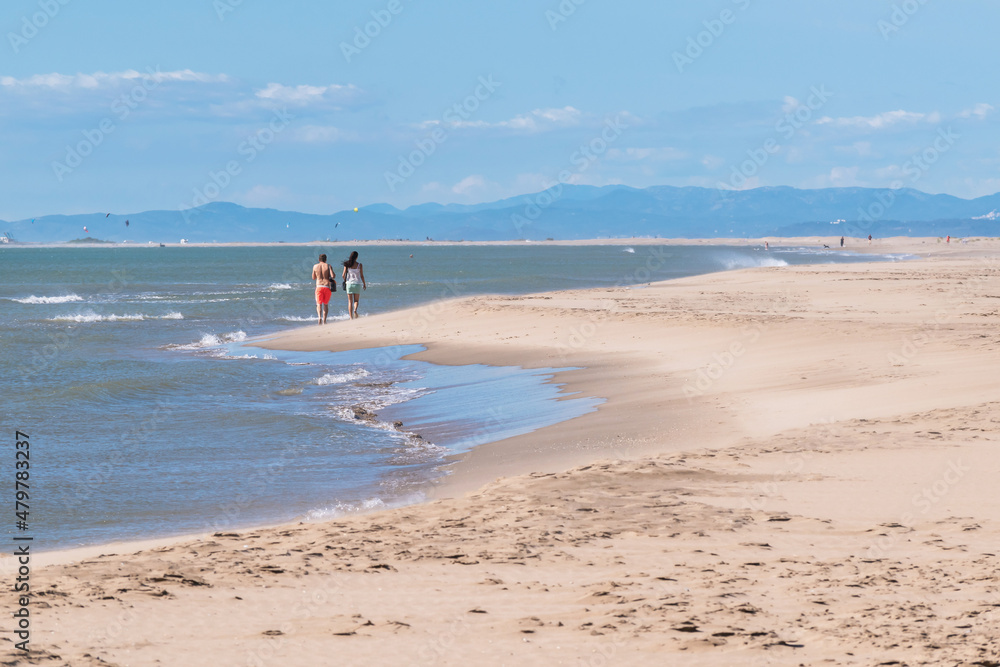 Couple walking on the Beach of Eucaliptos-Delta del Ebro Couple walking on the Beach of Eucaliptos-Delta del Ebro