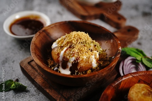 Raj Kachori or Kachouri - Indian deep fried snack stuffed with potatoestopped with yogurt cutneys and sev photo