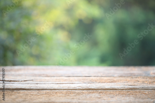 Wooden table surface with green nature background