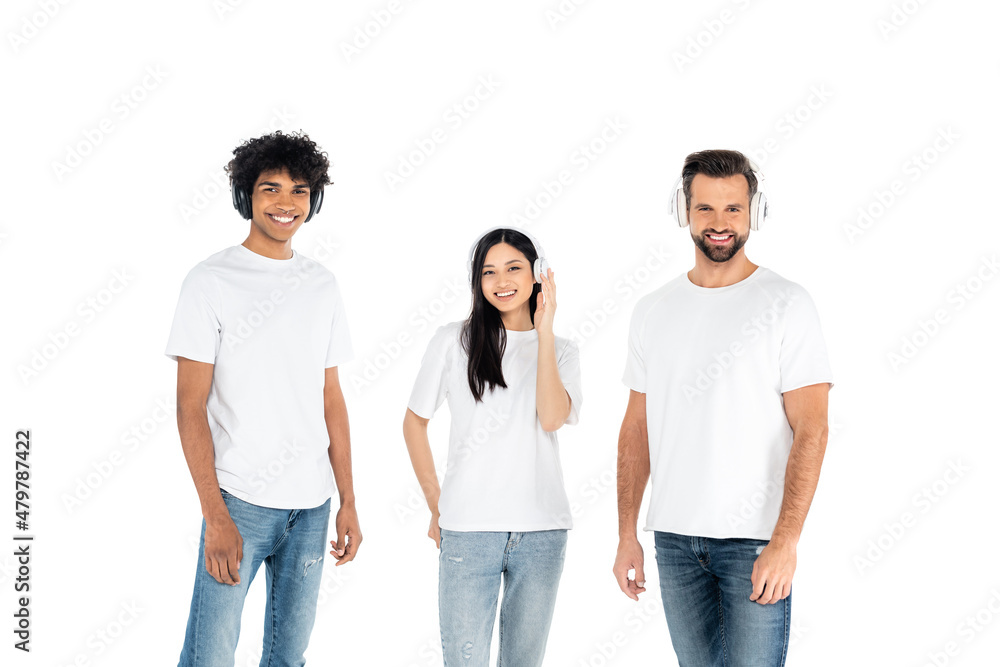 happy multiethnic men and asian woman in headphones looking at camera isolated on white. happy multiethnic men and asian woman in headphones looking at camera isolated on white.