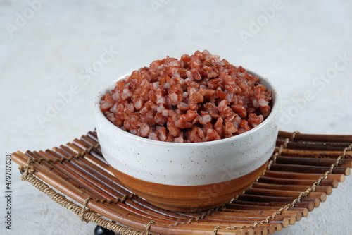 cooked red rice in white bowl on white background	