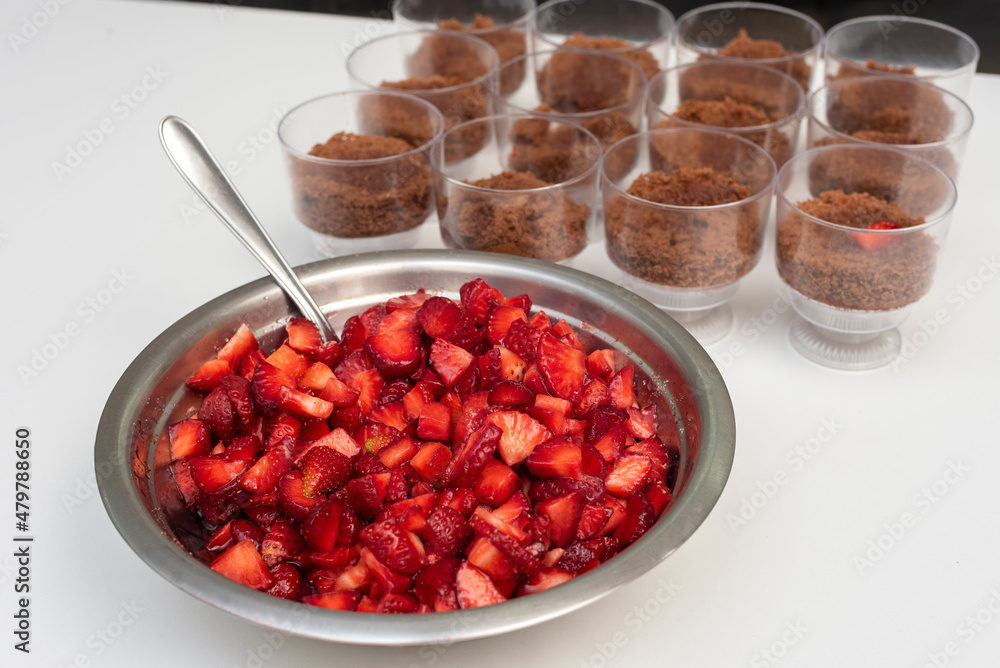 Pastry chef preparing step by step delicious dessert black forest or chip with chocolate biscuit, cream and fresh strawberries in shot glasses Pastry chef preparing step by step delicious dessert black forest or chip with chocolate biscuit, cream and fresh strawberries in shot glasses