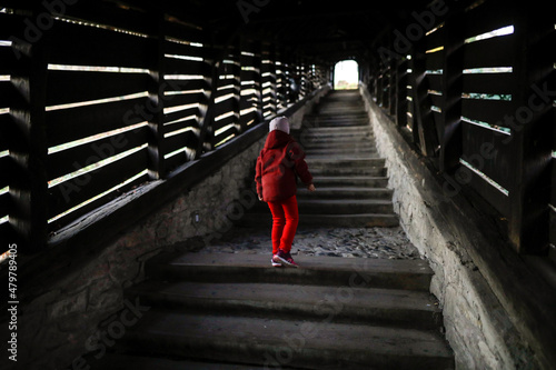 Little girl walks up the famous Covered Stairway (Scara acoperita) or The Scholars' Stairs, that lead up from the fortress and town centre up the hill. photo