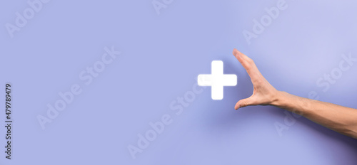 Businessman, man hold in hand offer positive thing such as profit, benefits, development, CSR represented by plus sign.The hand shows the plus sign