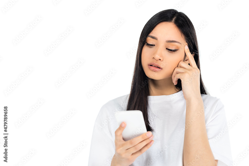 thoughtful asian woman touching head while looking at mobile phone isolated on white. thoughtful asian woman touching head while looking at mobile phone isolated on white.