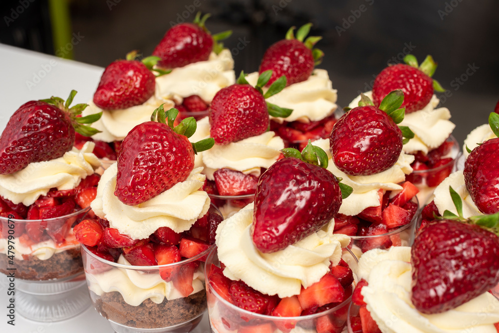 Pastry chef preparing step by step delicious dessert black forest or chip with chocolate biscuit, cream and fresh strawberries in shot glasses Pastry chef preparing step by step delicious dessert black forest or chip with chocolate biscuit, cream and fresh strawberries in shot glasses