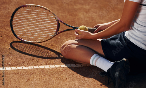 On the ground. Female tennis player is on the court at daytime © standret