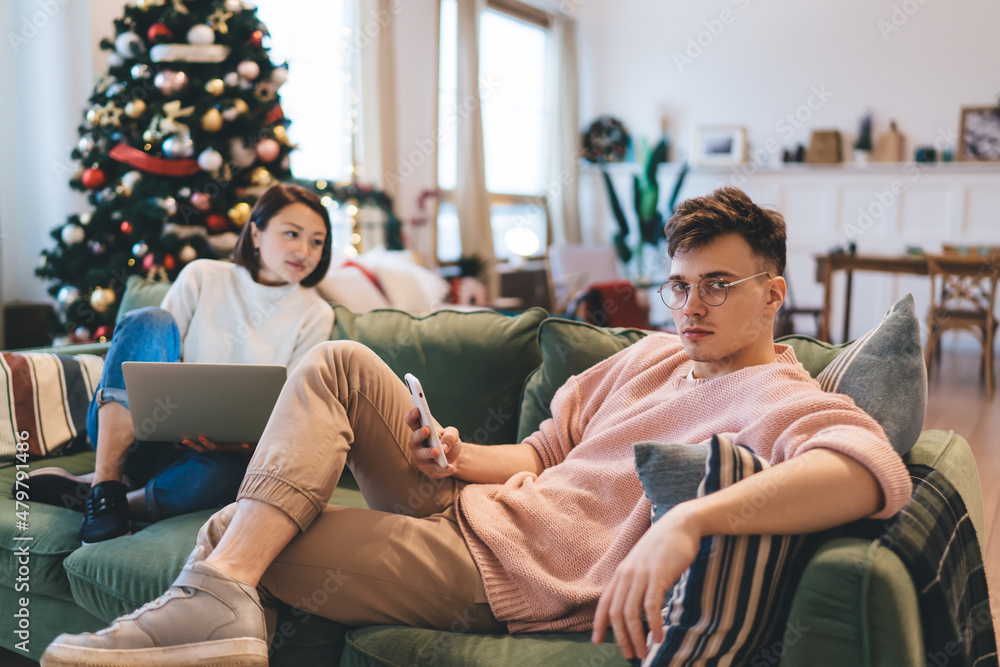 Obraz premium Woman watching on laptop and man using smartphone