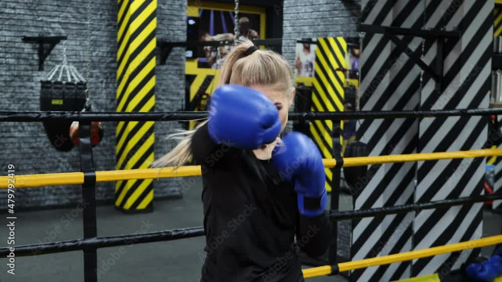 Young athletic boxer girl hits the camera with a glove. Young athletic boxer girl hits the camera with a glove.