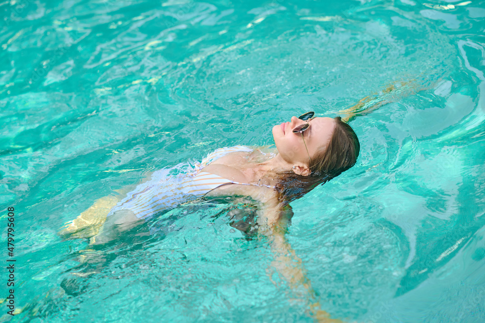 Young woman laying on water and looking relaxed