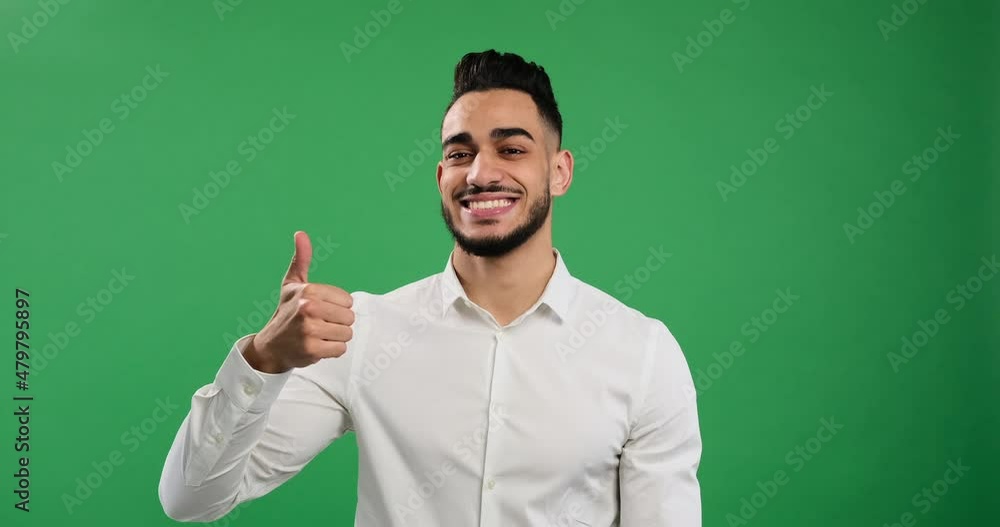 Businessman giving thumbs up gesture over green background Businessman giving thumbs up gesture over green background