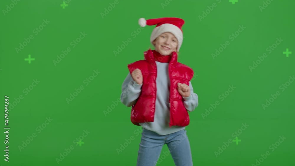 girl in hat of Santa Claus is counting on green screen . Lovely young Caucasian girl dancing . Happy kid singing a song girl in hat of Santa Claus is counting on green screen . Lovely young Caucasian girl dancing . Happy kid singing a song