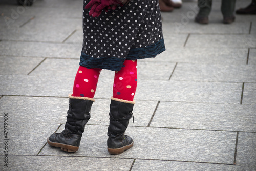 Closeup of red socks on legs of woman standing in the street