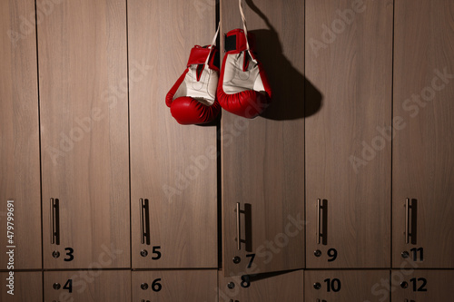 фотографія Red boxing gloves hanging on locker door in changing room