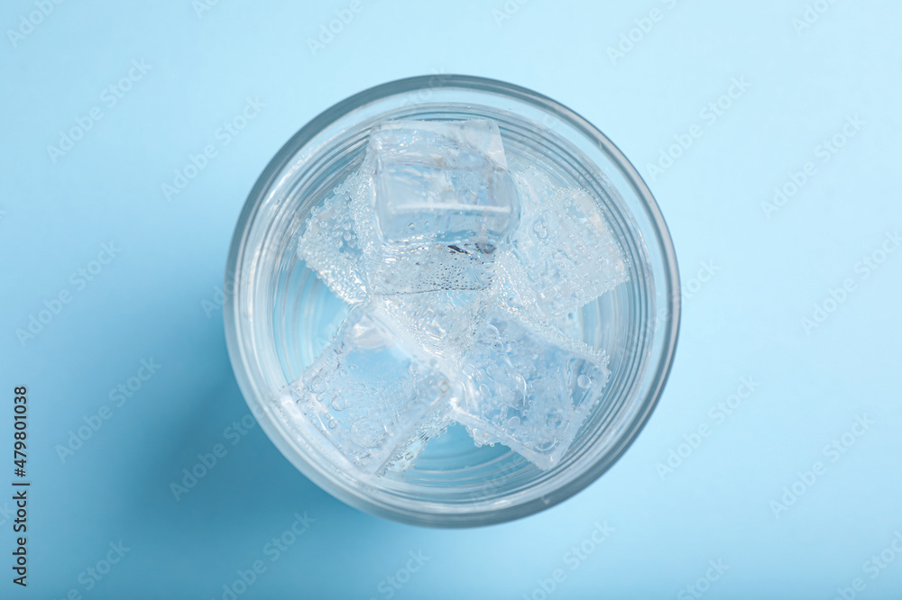 Glass of soda water with ice on light blue background, top view Glass of soda water with ice on light blue background, top view