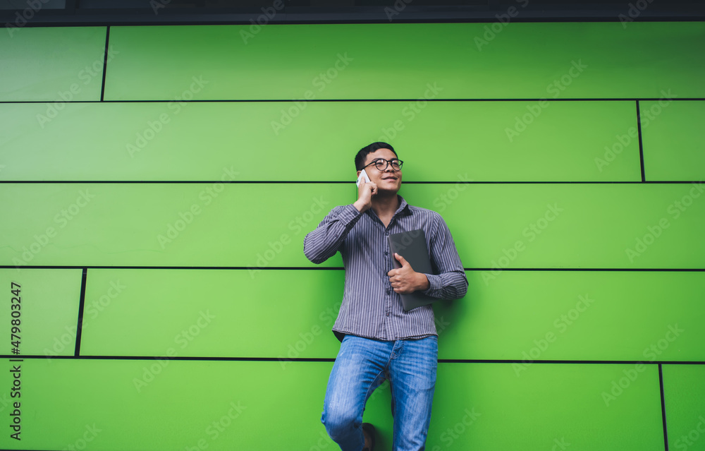 Guy talking on smartphone on green wall background Guy talking on smartphone on green wall background