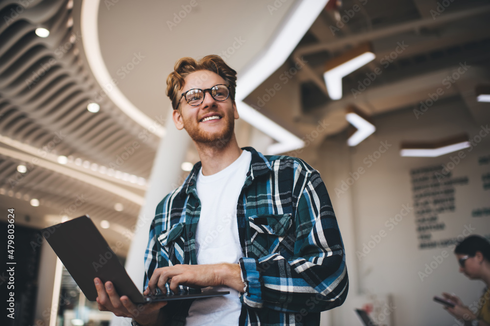 Young caucasian guy using laptop in office space