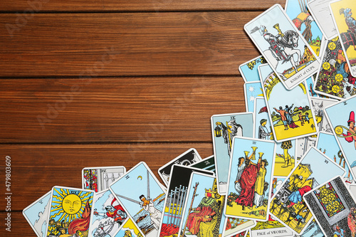 Tarot cards on wooden table, top view. Space for text photo