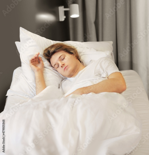 young sleeping man lying on the bed