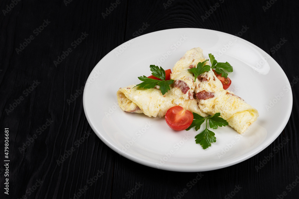 Omelet with Ham and Cheese and fresh vegetable on black wooden background Omelet with Ham and Cheese and fresh vegetable on black wooden background