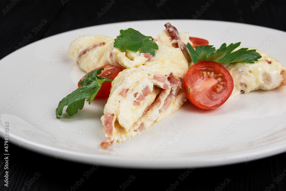Omelet with Ham and Cheese and fresh vegetable on black wooden background Omelet with Ham and Cheese and fresh vegetable on black wooden background