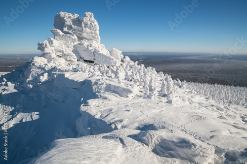 Mountain snow-covered slope in cold polar winter on a sunny day