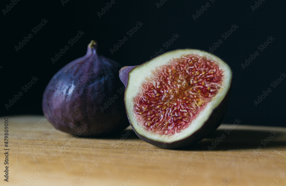 Ripe figs on a wooden kitchen table. Fresh edible fig fruits of Ficus carica. Ripe figs on a wooden kitchen table. Fresh edible fig fruits of Ficus carica.