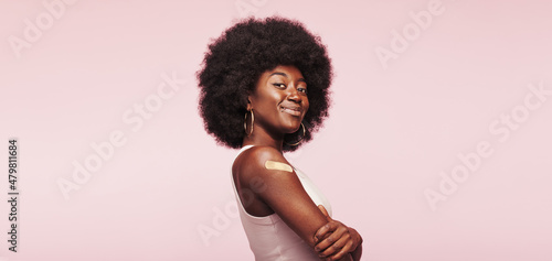 Bild auf Leinwand Smiling African woman with a vaccination bandage