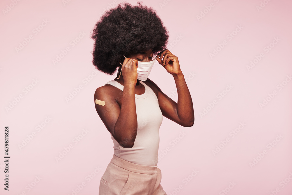 Young African woman putting a face mask on Young African woman putting a face mask on