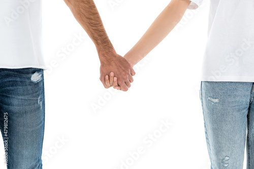 cropped view of couple in jeans holding hands isolated on white.
