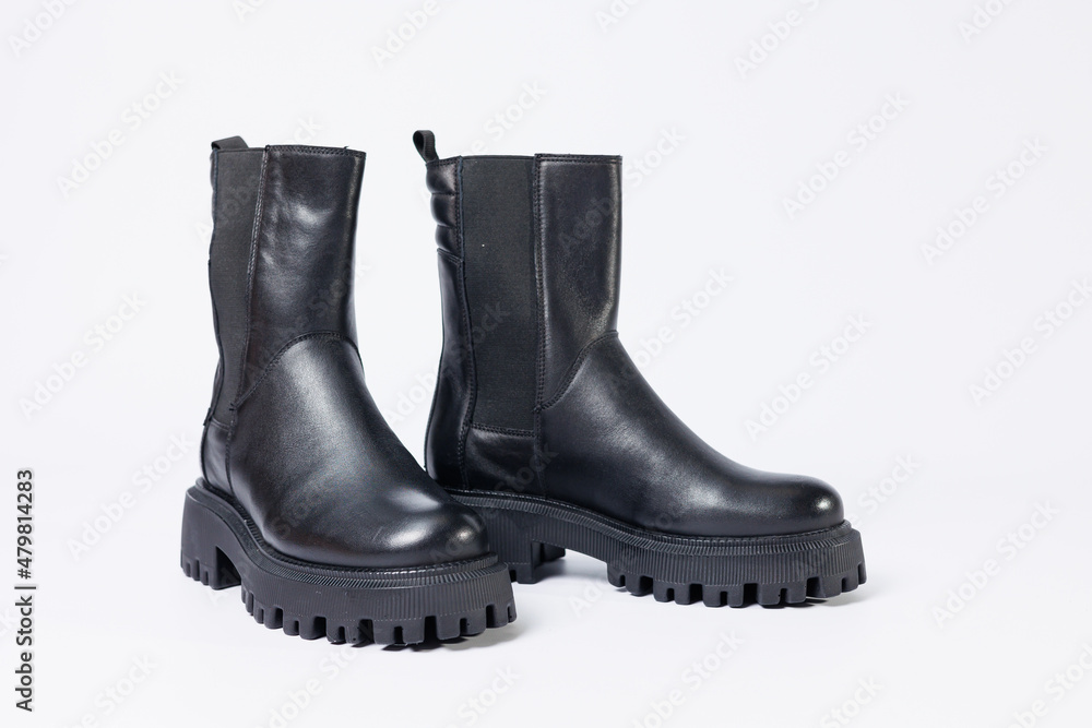 Women's shoes on a white background. Close-up of women's black leather chelsea boots on a white background. Shoes for the city. Fashion, design and footwear concept. Women's shoes on a white background. Close-up of women's black leather chelsea boots on a white background. Shoes for the city. Fashion, design and footwear concept.