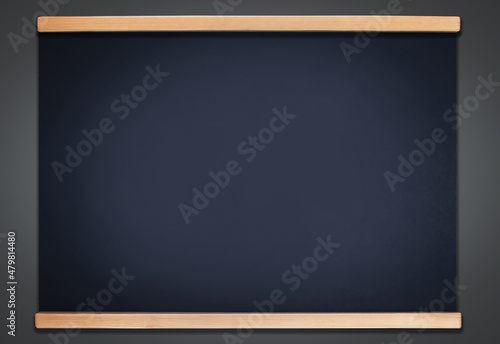 Old shabby stained blank chalkboard in a wooden border on a gray wall