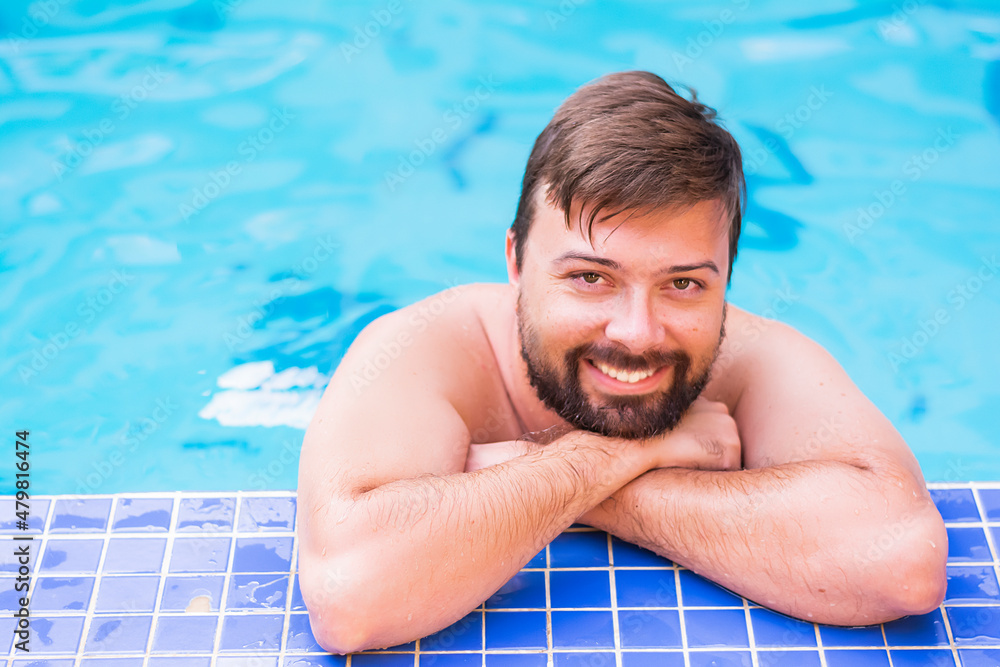 Positive smile tourist man with beard in swimming pool positive review of the resort