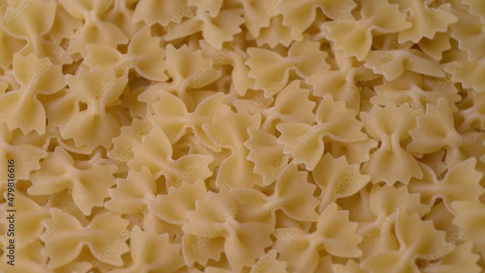 Close up of raw Italian farfalle pasta,  rotating. Uncooked traditional food. Mediterranean cuisine concept