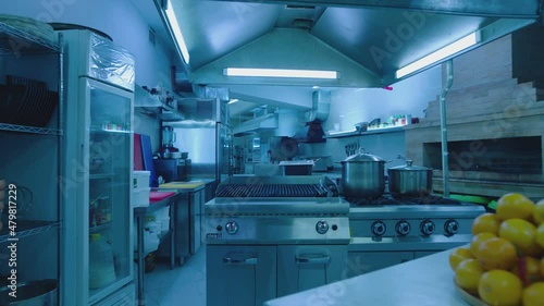 Professional commercial empty kitchen at the restaurant or cafe . Camera moving inside interior of big clean modern kitchen . Metallic kitchen equipment , kitchenware . Led lights , slow motion
