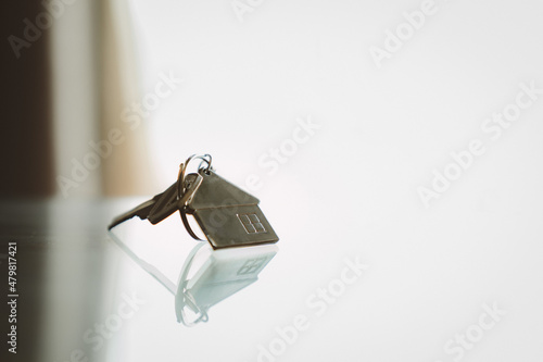 House model and key in home with light from window. Real estate agent offer house, property insurance and security, affordable housing concepts