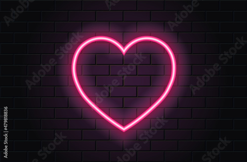 Pink neon heart for valentines day on black brickwall background