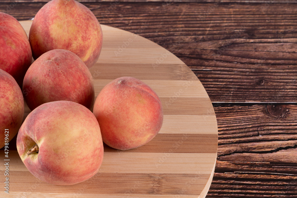 Tasty peaches (Prunus persica, in Latin), on wooden board, on rustic wooden table. Selective focus. Tasty peaches (Prunus persica, in Latin), on wooden board, on rustic wooden table. Selective focus.