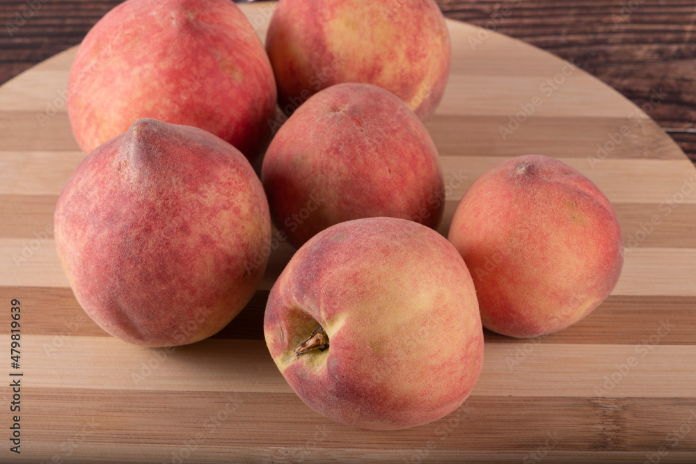 Tasty peaches (Prunus persica, in Latin), on wooden board, on rustic wooden table. Selective focus. Tasty peaches (Prunus persica, in Latin), on wooden board, on rustic wooden table. Selective focus.