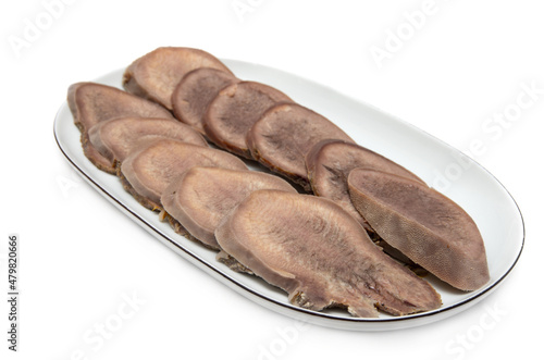Boiled beef tongue on plate isolated on white background