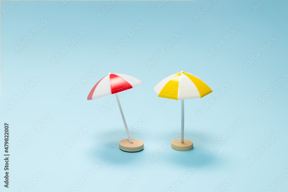 Fototapeta premium Yellow and red umbrella on a blue background.