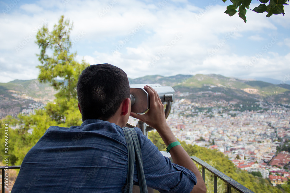 A young guy looks through the observation binoculars Turkey, Kyzyl Kul