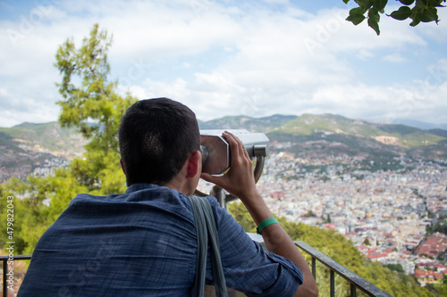 A young guy looks through the observation binoculars Turkey, Kyzyl Kul