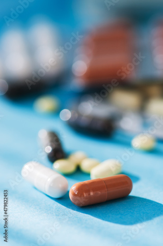Various tablets, pills on blue background.