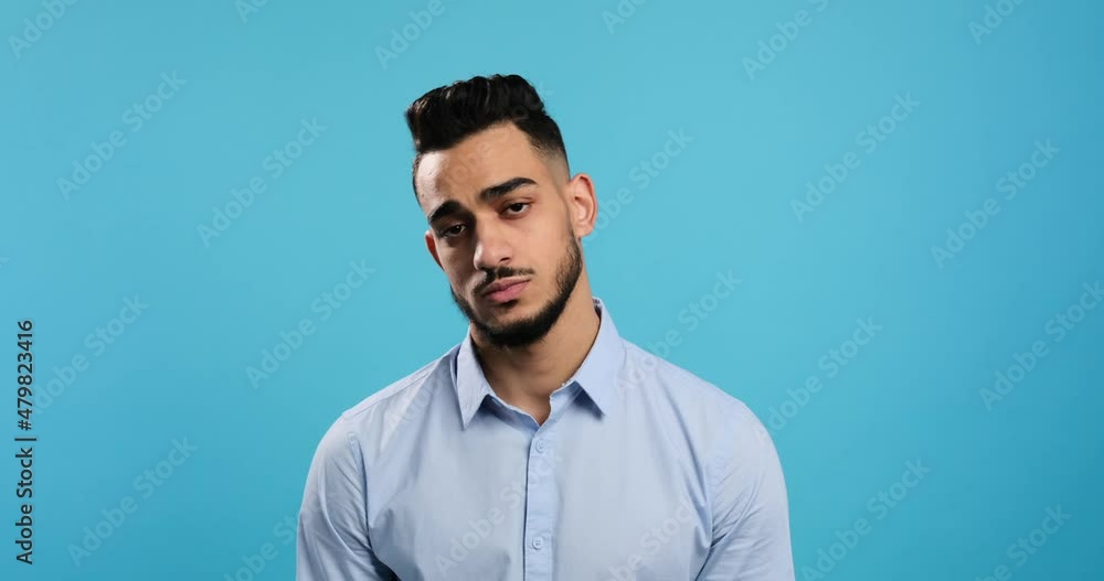 Portrait of disappointed man regretting his deeds over blue background Portrait of disappointed man regretting his deeds over blue background