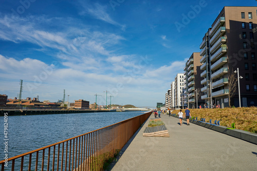 People walking along the banks of the Nervión river on a sunny winter day