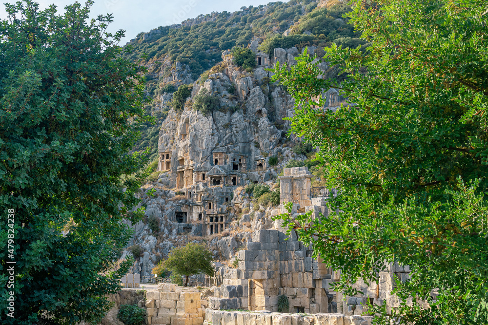 famous complex of rock tombs with the ruins of an ancient theater in the foreground in Myra