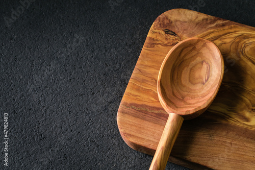 Empty wooden kitchen spoon on the chopping board. Closeup.